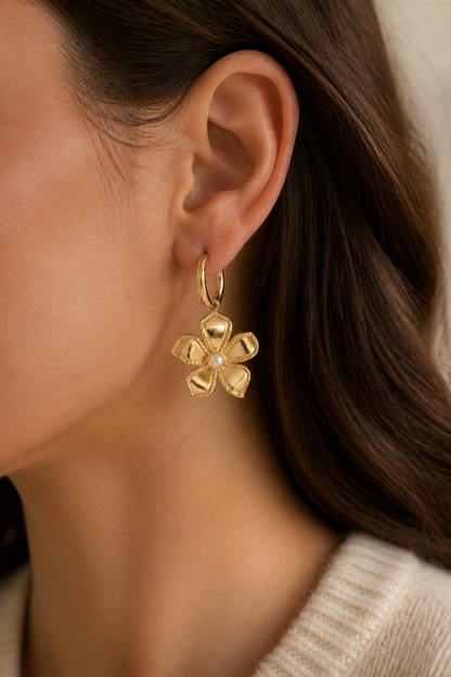 Gouden grote bloem oorbellen in het oor van een vrouw, waterproof stainless steel damessieraad