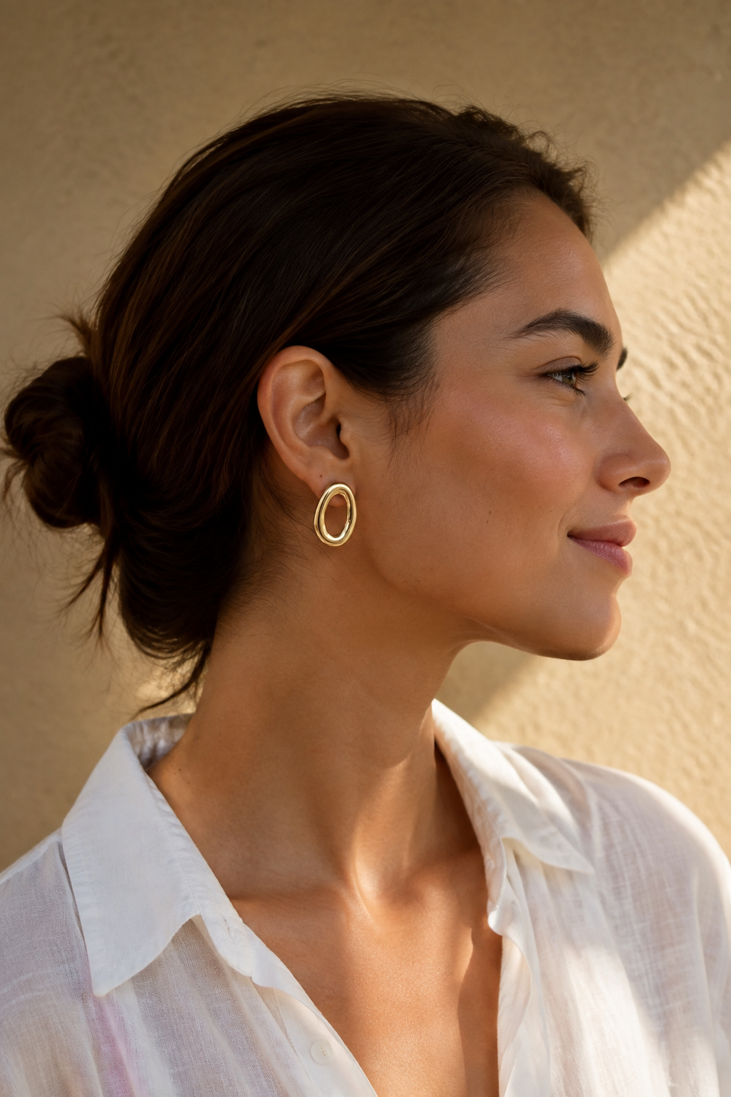 Vrouw draagt gouden grote ovale ringen oorbellen, hypoallergeen stainless steel damessieraad