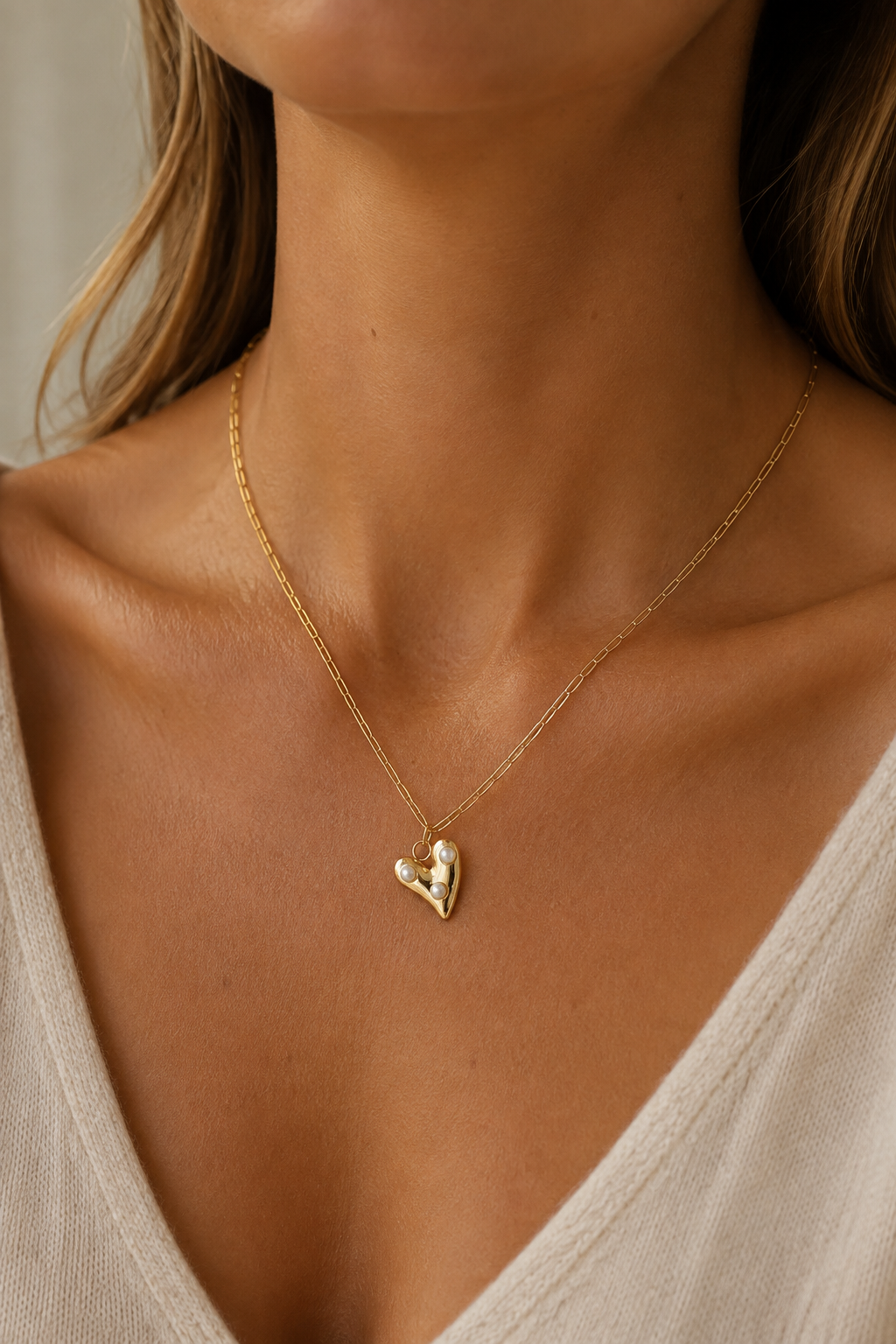 Gouden hartje parels ketting om de hals van een vrouw, waterproof stainless steel damessieraad