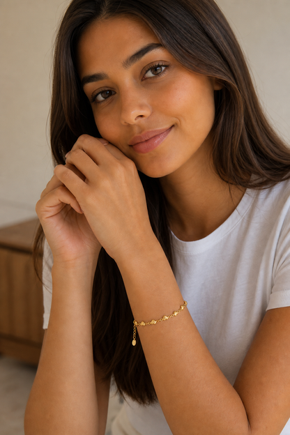 Vrouw draagt een gouden hartjes armband, hypoallergeen stainless steel damessieraad