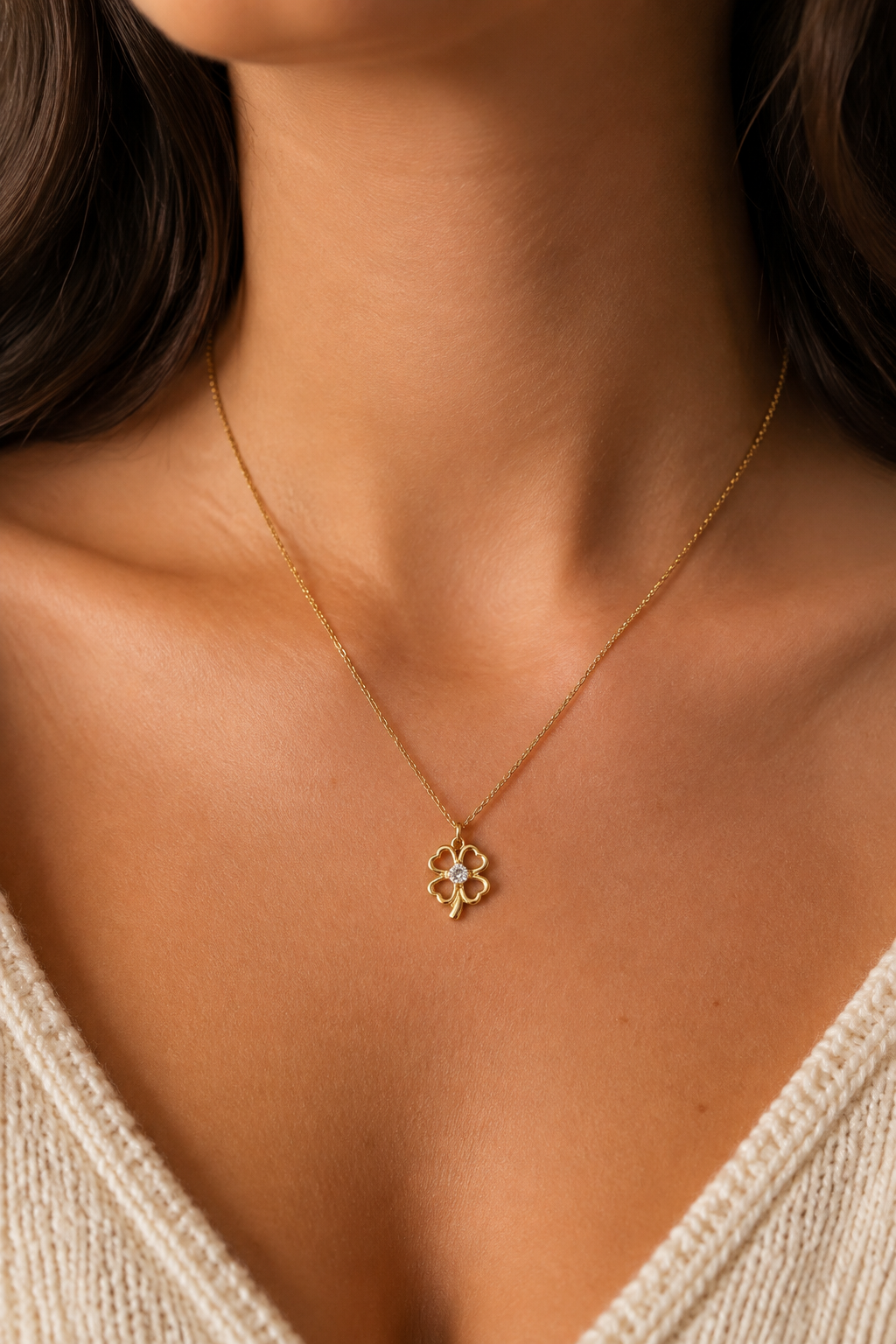 Gouden klavertje parelmoer ketting om de hals van een vrouw, waterproof stainless steel damessieraad