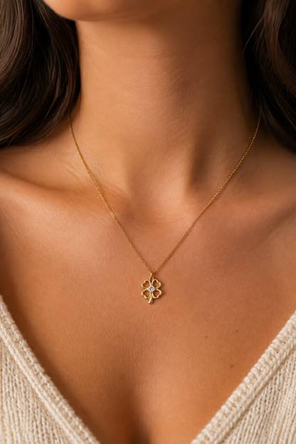 Gouden klavertje parelmoer ketting om de hals van een vrouw, waterproof stainless steel damessieraad
