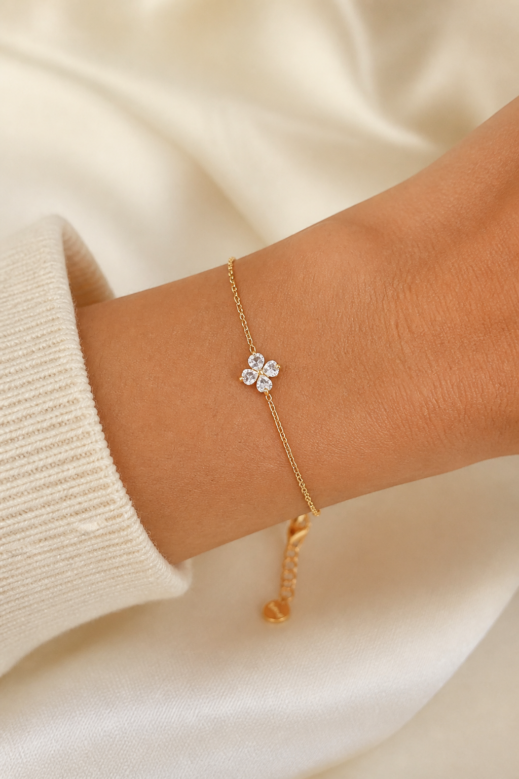 Gouden klavertje vier armband om de pols van een vrouw, waterproof stainless steel damessieraad