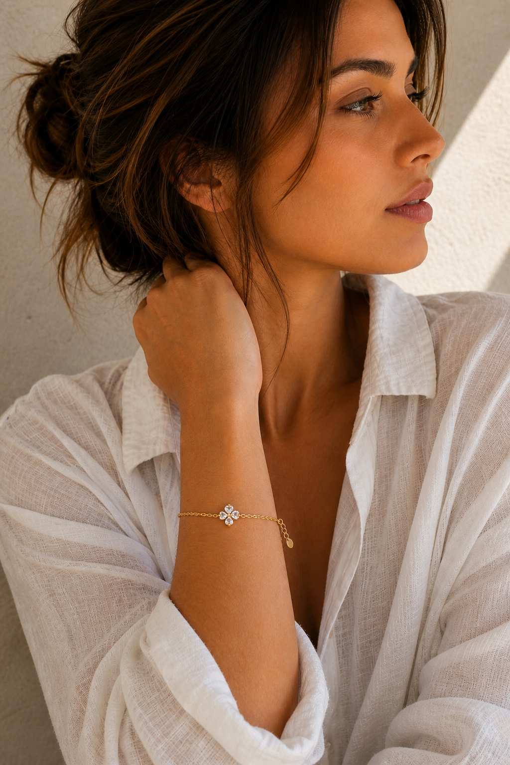 Vrouw draagt een gouden klavertje vier armband, hypoallergeen stainless steel damessieraad