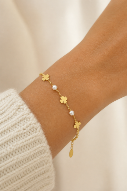 Gouden klavertjes parels armband om de pols van een vrouw, waterproof stainless steel damessieraad