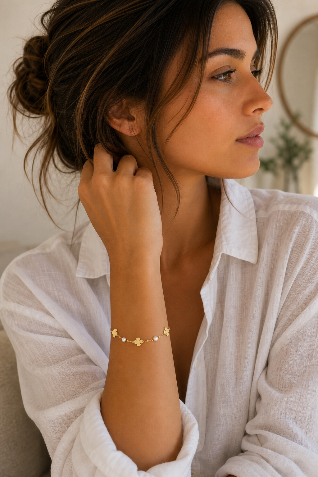 Vrouw draagt een gouden klavertjes parels armband, hypoallergeen stainless steel damessieraad