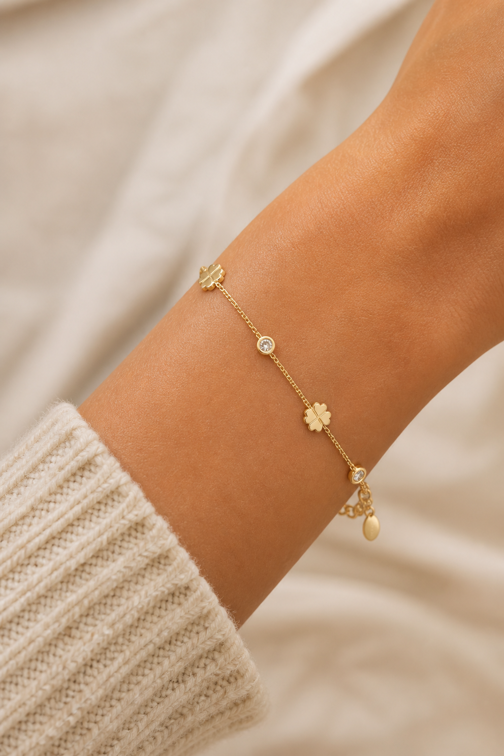 Gouden klavertjes steentjes armband om de pols van een vrouw, waterproof stainless steel damessieraad