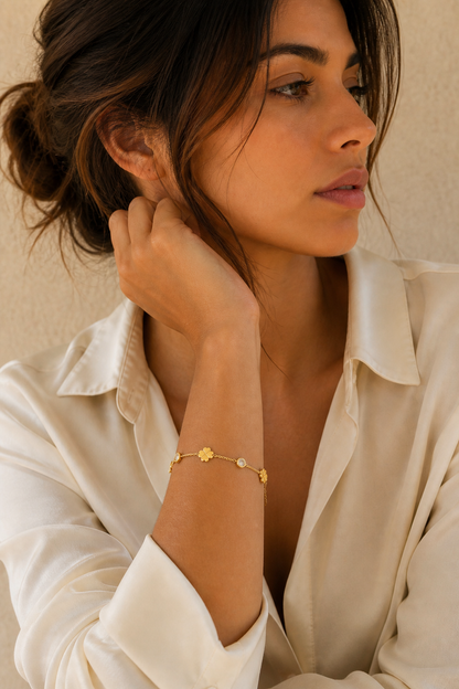 Vrouw draagt een gouden klavertjes steentjes armband, hypoallergeen stainless steel damessieraad