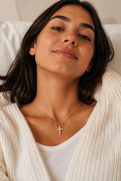Vrouw draagt een gouden kruisje steentjes ketting, hypoallergeen stainless steel damessieraad
