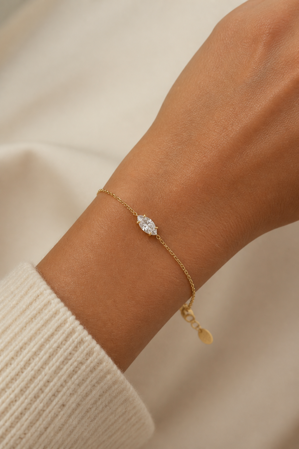 Gouden ovaal steentje armband om de pols van een vrouw, waterproof stainless steel damessieraad