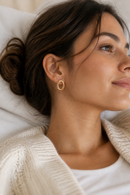 Vrouw draagt gouden ovale ringen oorbellen, hypoallergeen stainless steel damessieraad
