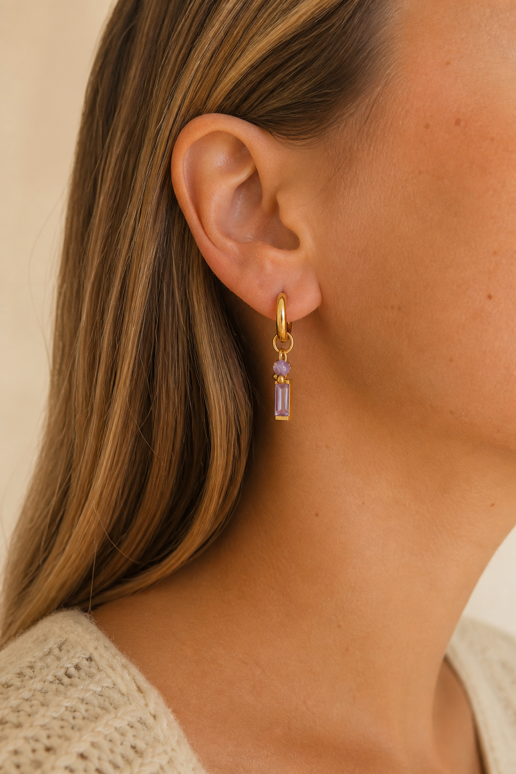 Gouden paarse steen oorbellen in het oor van een vrouw, waterproof stainless steel damessieraad