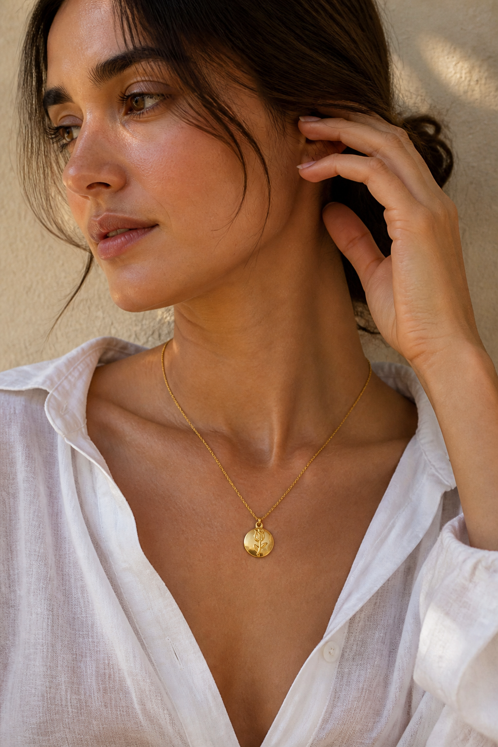 Vrouw draagt een gouden roosje bolletje ketting, hypoallergeen stainless steel damessieraad