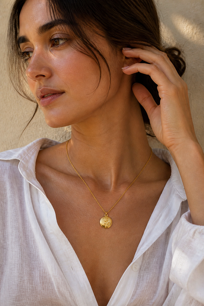 Vrouw draagt een gouden roosje bolletje ketting, hypoallergeen stainless steel damessieraad