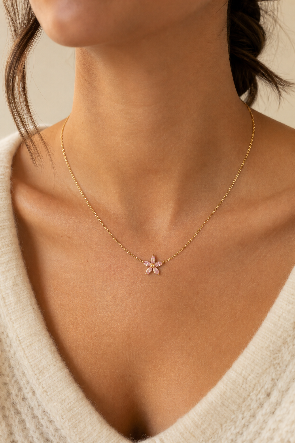 Gouden roze bloemetje ketting om de hals van een vrouw, waterproof stainless steel damessieraad