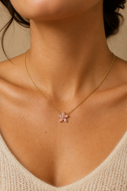 Vrouw draagt een gouden roze bloemetje ketting, hypoallergeen stainless steel damessieraad