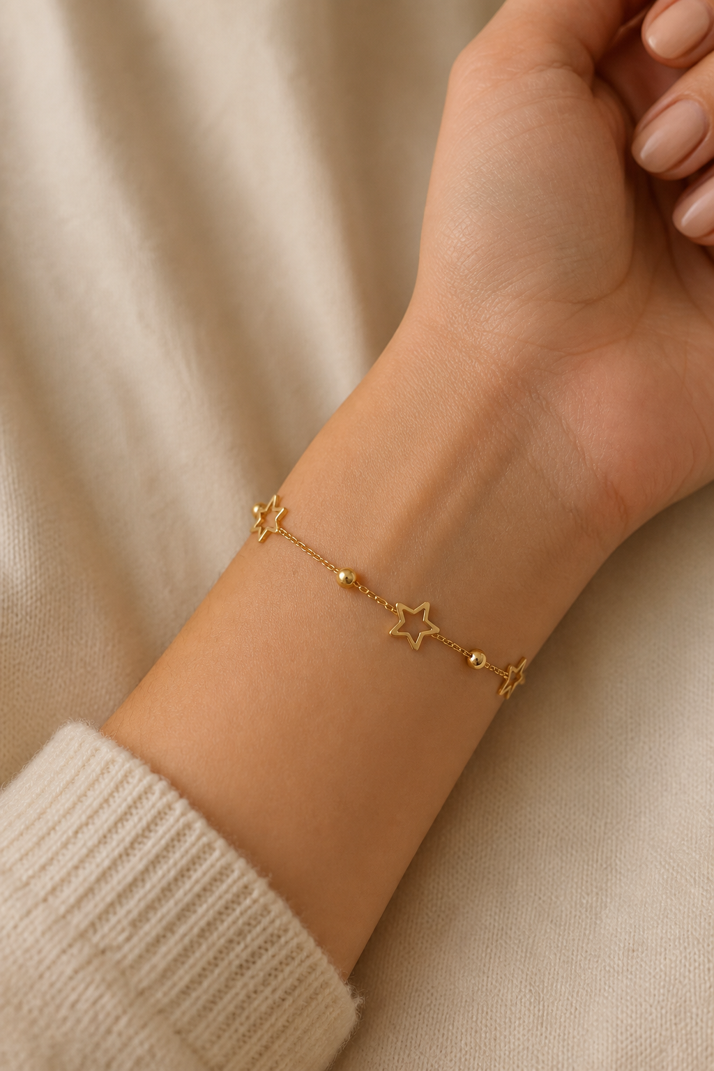 Gouden sterretjes armband om de pols van een vrouw, waterproof stainless steel damessieraad