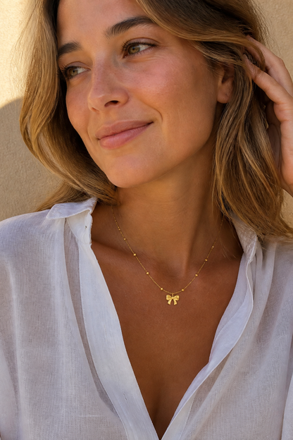 Vrouw draagt een gouden strikje ketting, hypoallergeen stainless steel damessieraad