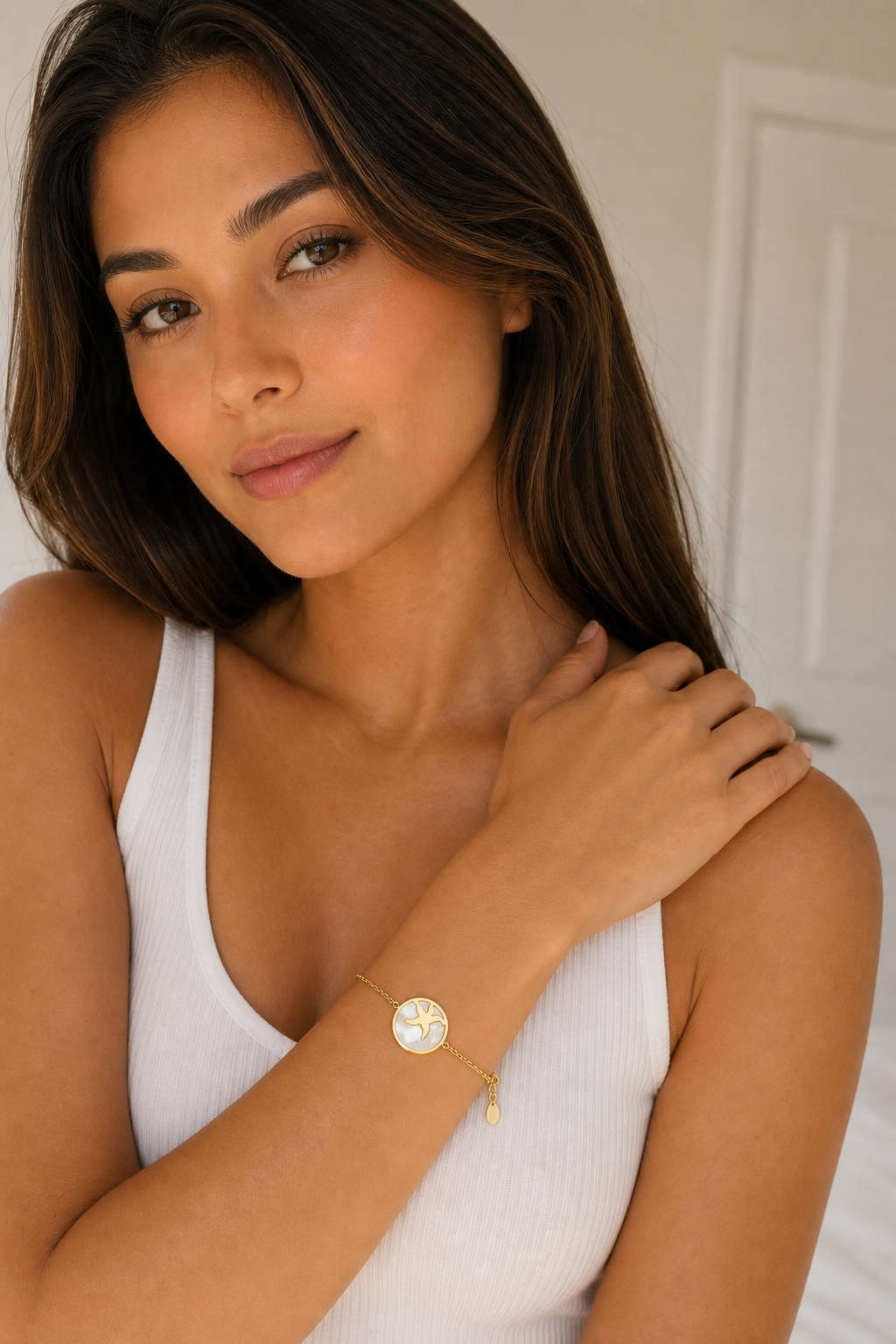 Vrouw draagt een gouden zeester armband, hypoallergeen stainless steel damessieraad