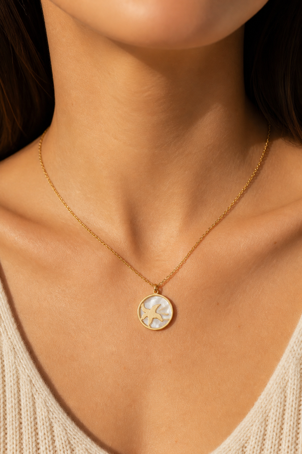 Gouden zeester parelmoer ketting om de hals van een vrouw, waterproof stainless steel damessieraad