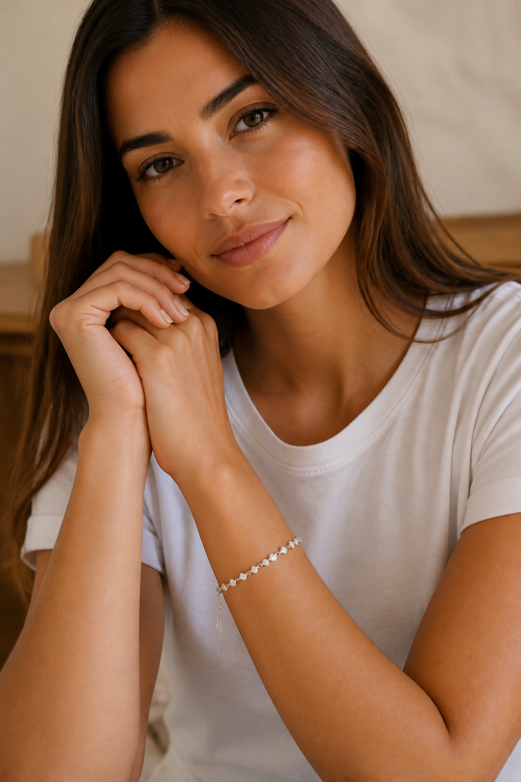 Vrouw draagt een zilveren hartjes armband, hypoallergeen stainless steel damessieraad