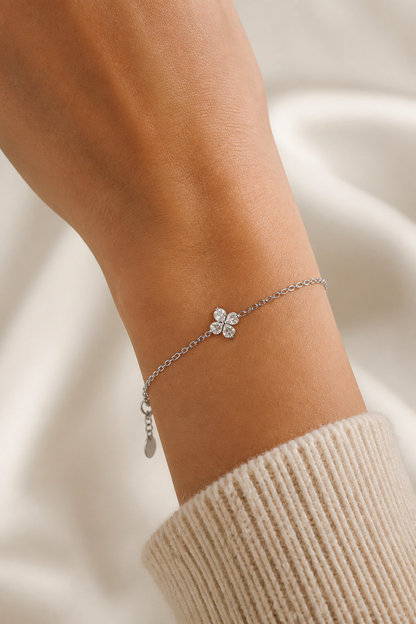 Zilveren klavertje vier armband om de pols van een vrouw, waterproof stainless steel damessieraad
