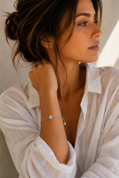 Vrouw draagt een zilveren klavertje vier armband, hypoallergeen stainless steel damessieraad