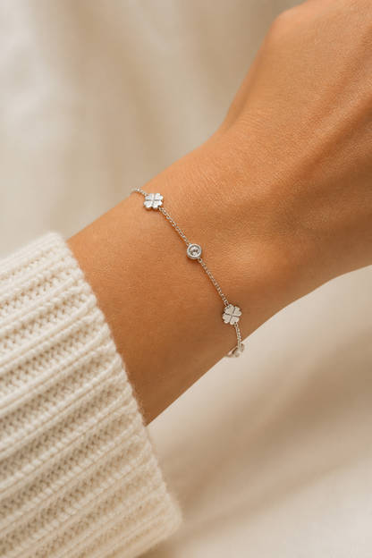 Zilveren klavertjes steentjes armband om de pols van een vrouw, waterproof stainless steel damessieraad