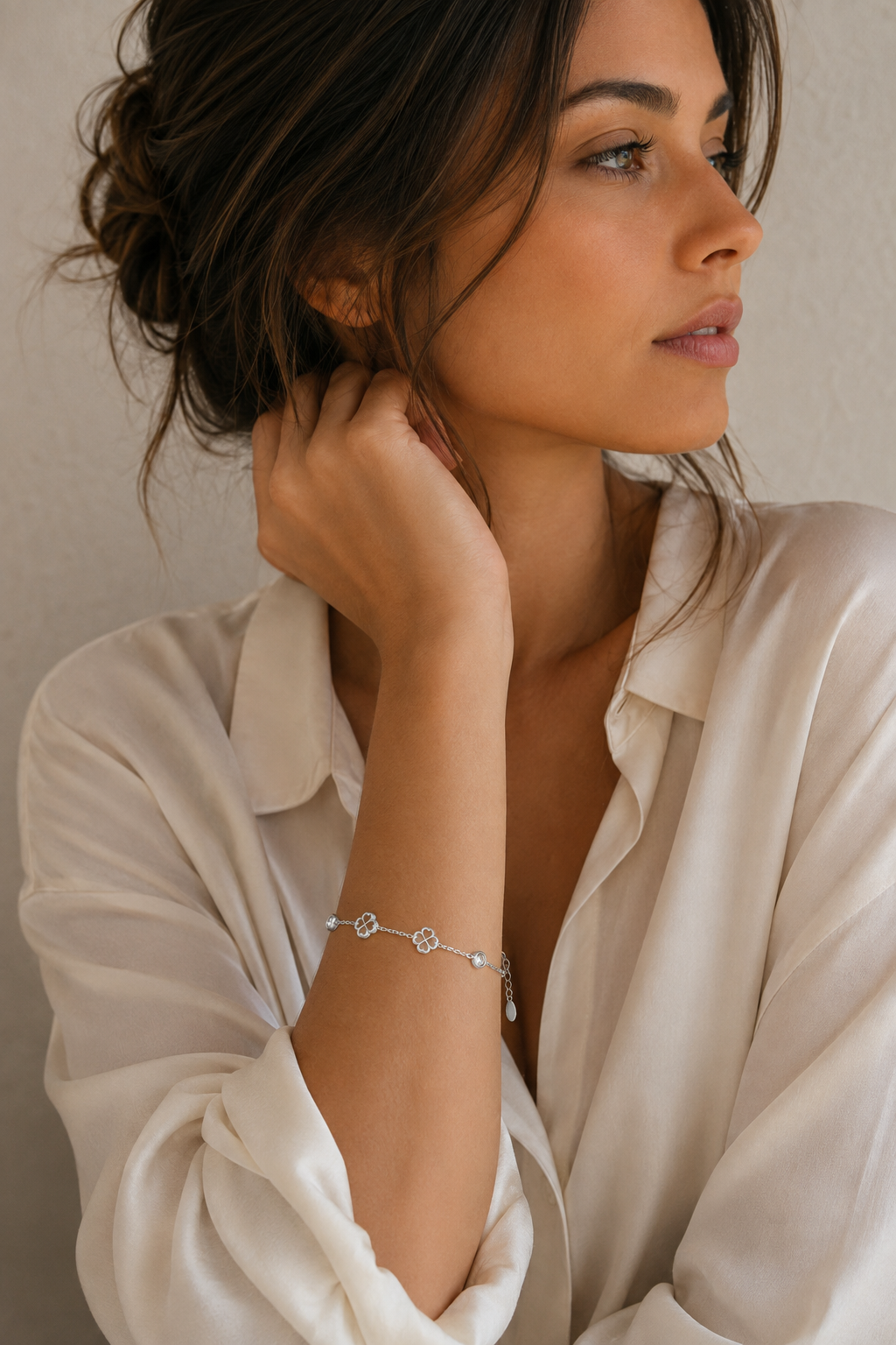 Vrouw draagt een zilveren klavertjes steentjes armband, hypoallergeen stainless steel damessieraad