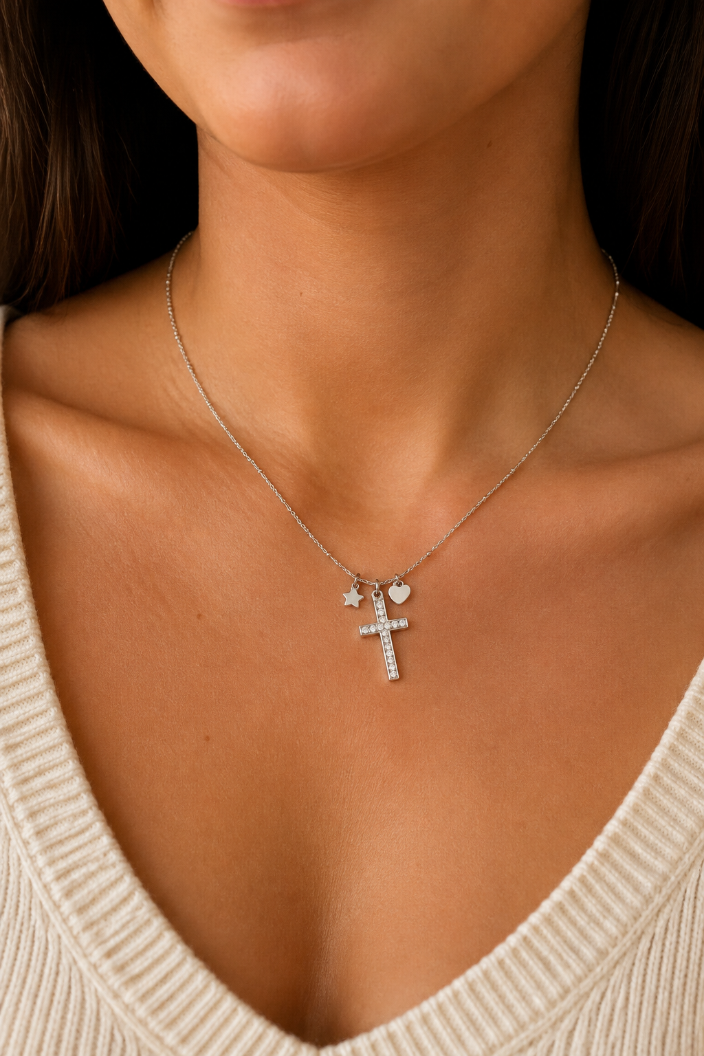 Zilveren kruisje steentjes ketting om de hals van een vrouw, waterproof stainless steel damessieraad