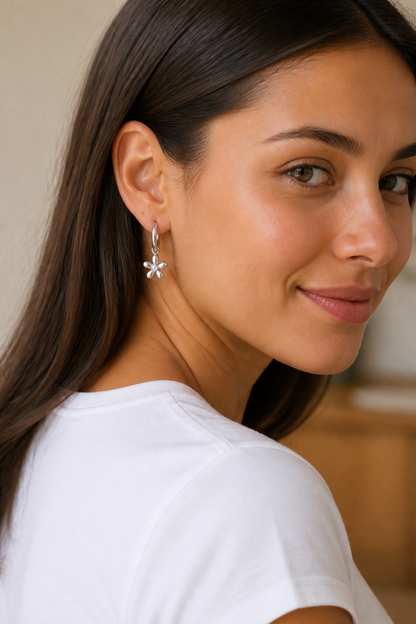 Vrouw draagt zilveren madeliefje parel oorbellen, hypoallergeen stainless steel damessieraad