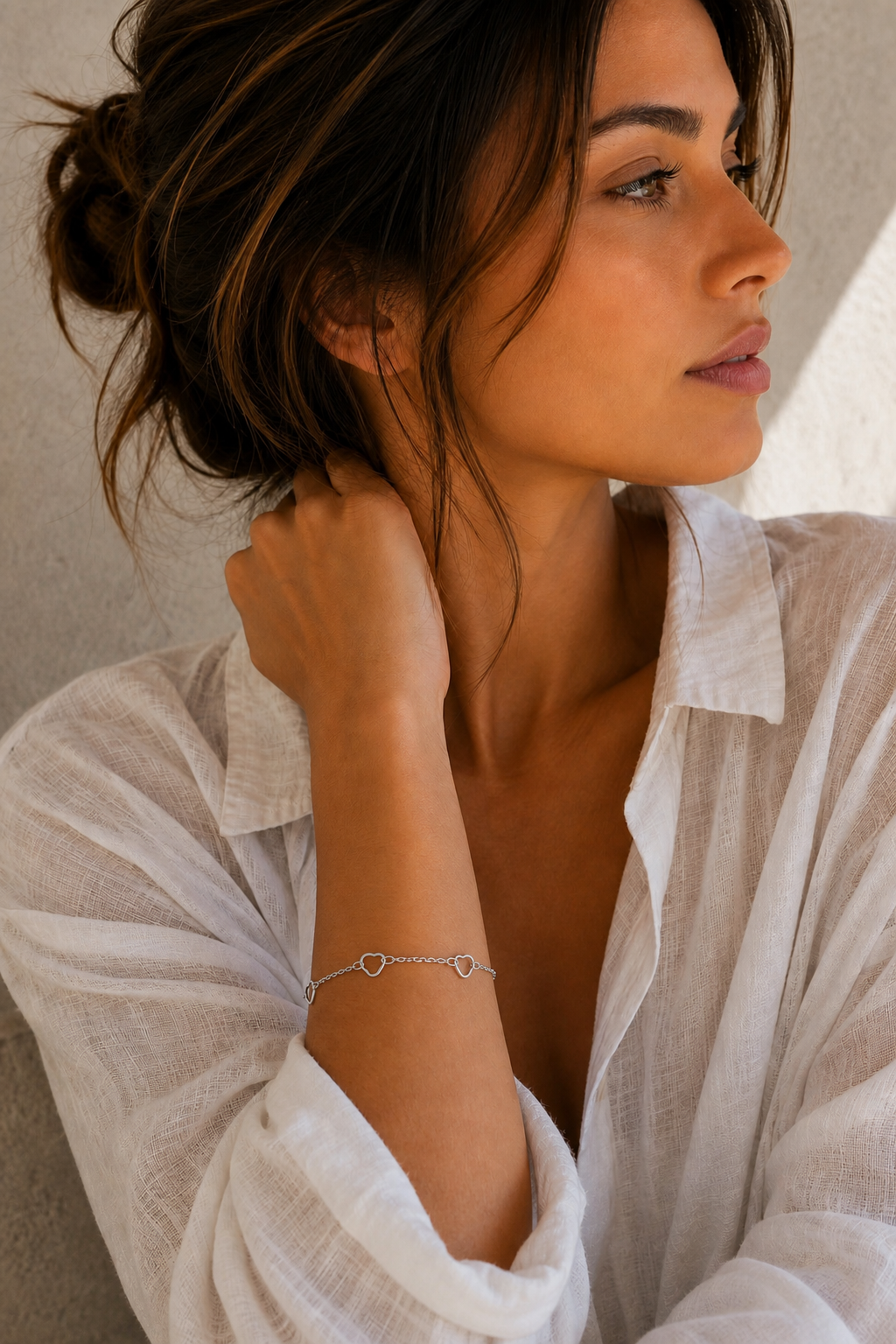 Vrouw draagt een zilveren open hartjes armband, hypoallergeen stainless steel damessieraad