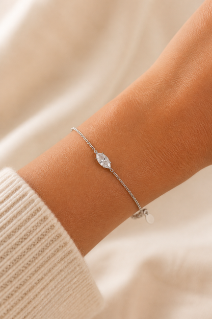 Zilveren ovaal steentje armband om de pols van een vrouw, waterproof stainless steel damessieraad