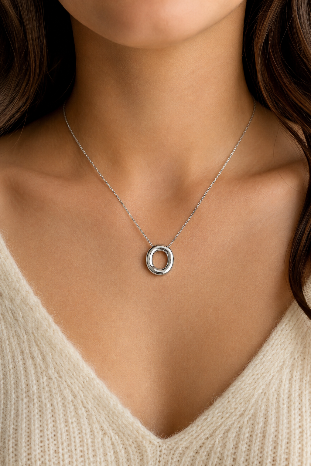 Zilveren ovale ring ketting om de hals van een vrouw, waterproof stainless steel damessieraad