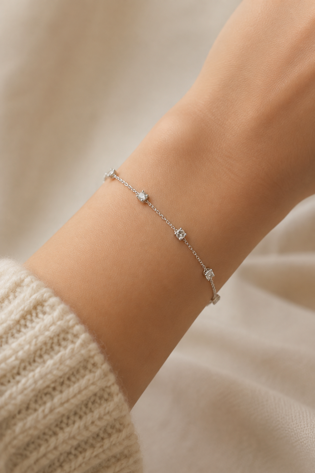 Zilveren steentjes armband om de pols van een vrouw, waterproof stainless steel damessieraad
