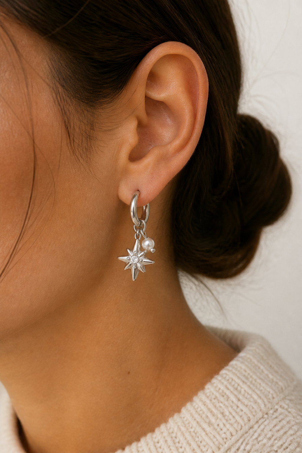 Zilveren ster parel oorbellen in het oor van een vrouw, waterproof stainless steel damessieraad