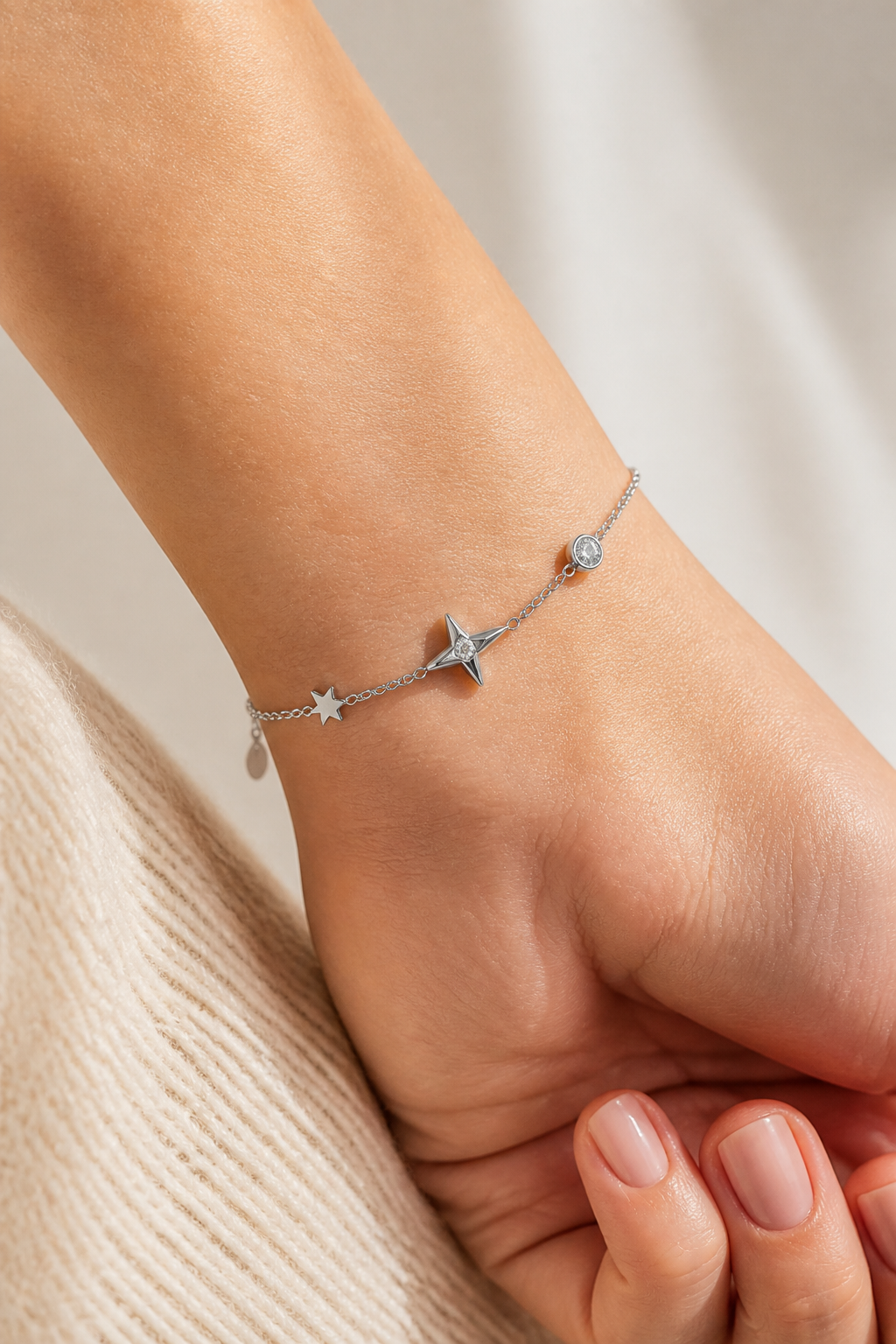 Zilveren sterren armband om de pols van een vrouw, waterproof stainless steel damessieraad
