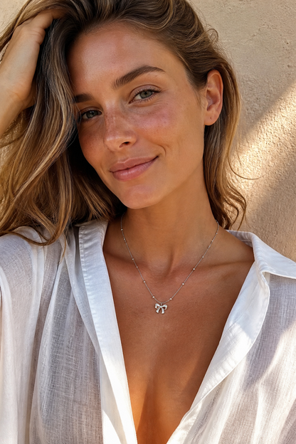 Vrouw draagt een zilveren strikje ketting, hypoallergeen stainless steel damessieraad