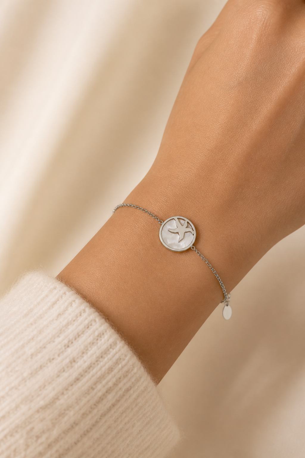 Zilveren zeester armband om de pols van een vrouw, waterproof stainless steel damessieraad
