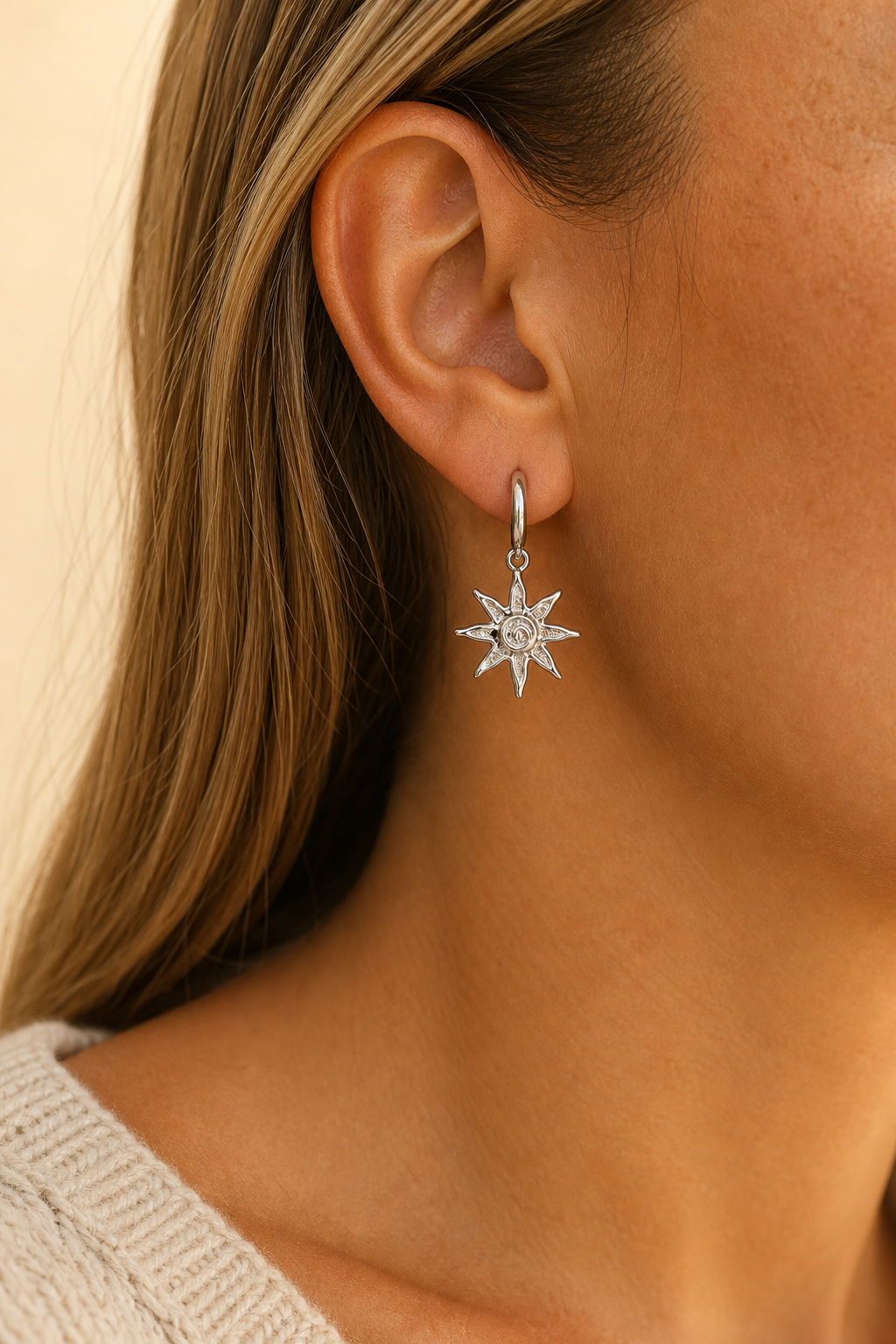 Zilveren zonnetje oorbellen in het oor van een vrouw, waterproof stainless steel damessieraad